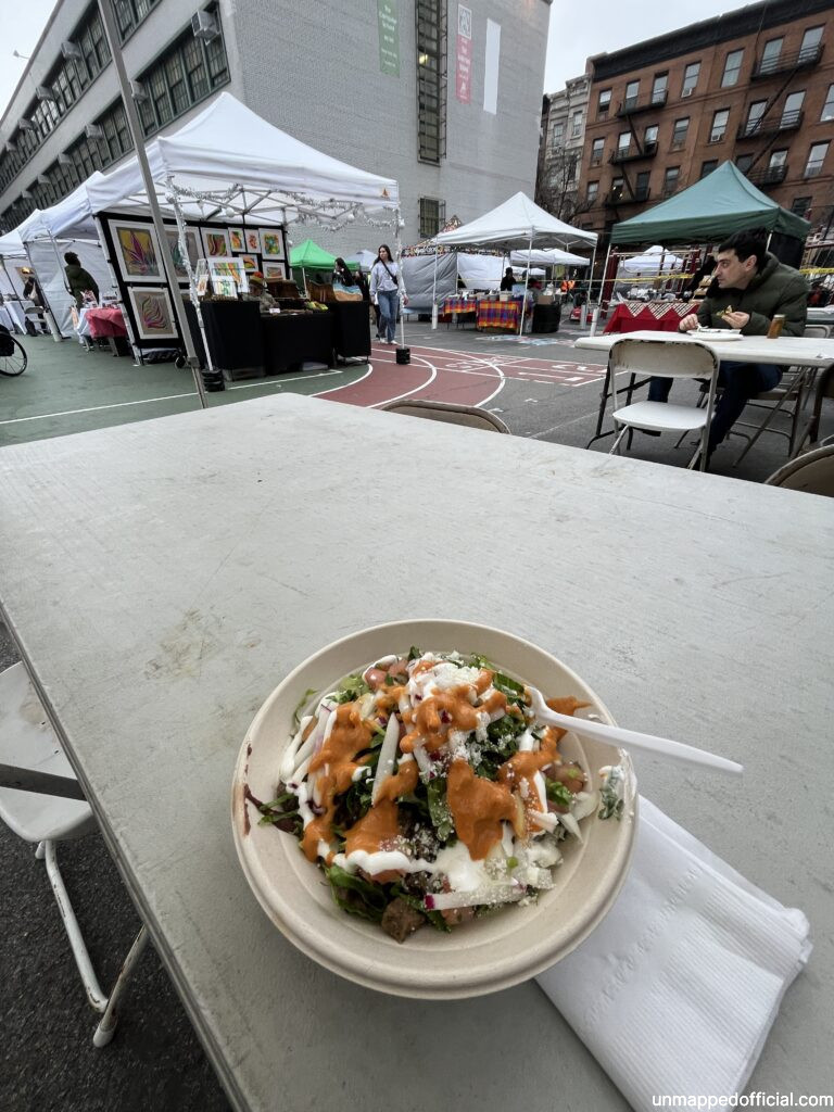a bowl of food on a table with the background of a flea market
