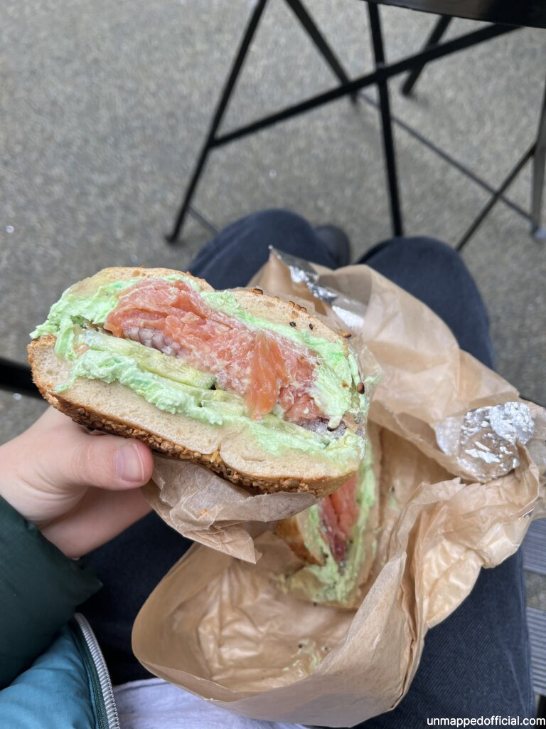 half cut view of a lox bagel with green wasabi cream cheese