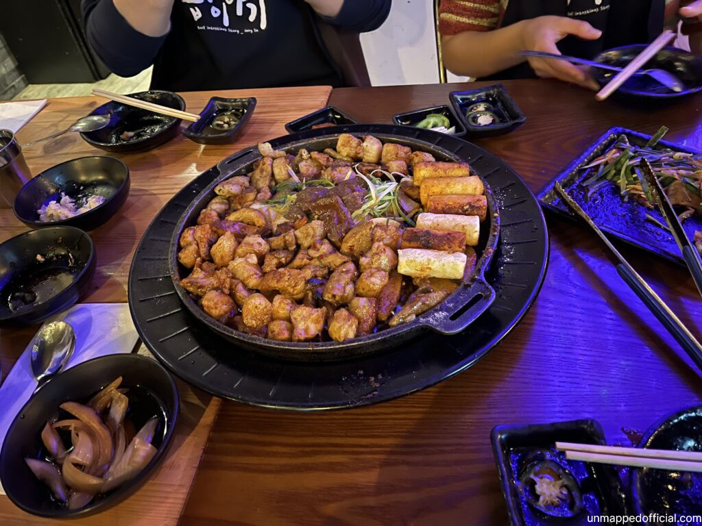 a large cast iron pan with Korean BBQ meats and rice cakes.