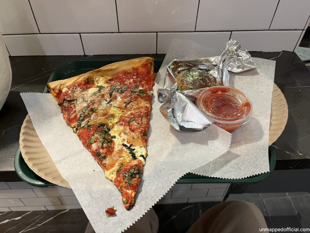 a slice of pizza on a plate on a counter