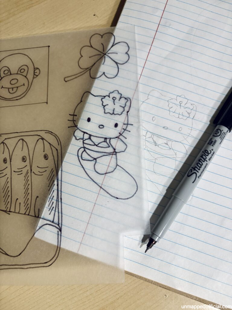 shrinky dink shrink plastic with drawings traced overtop of a paper sketch