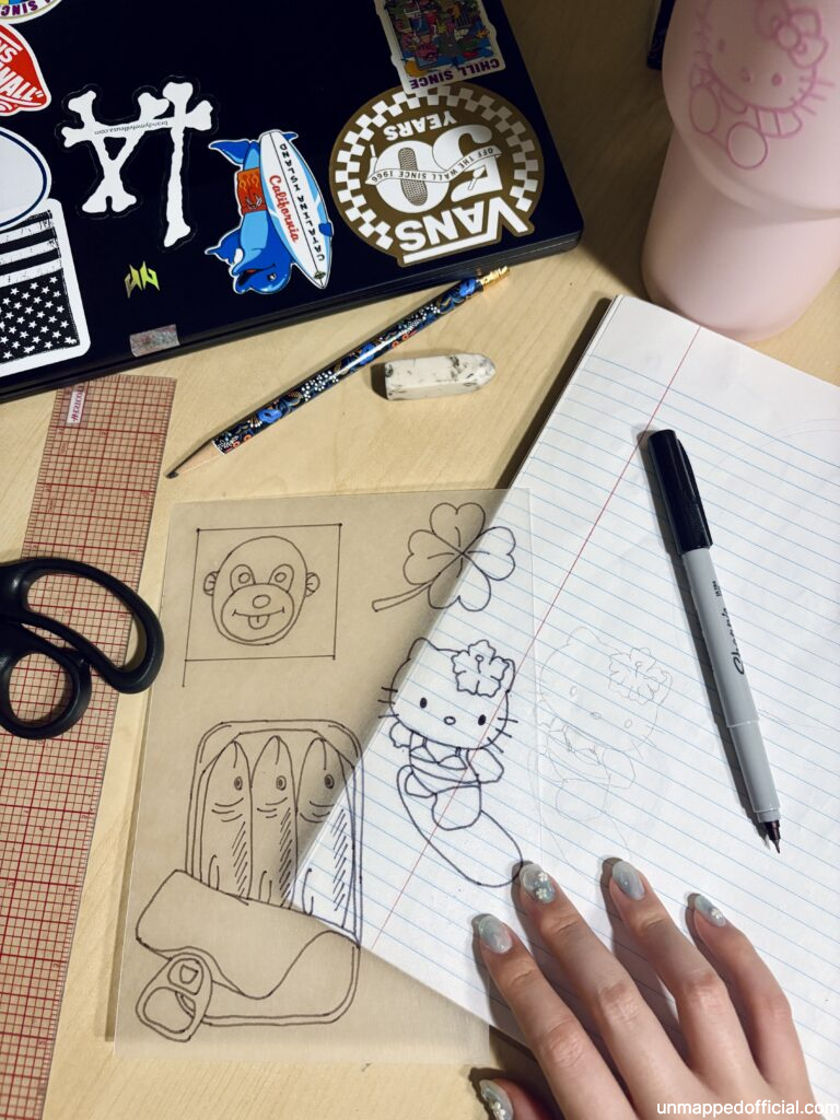 Desk with various items used to sketch on shrinky dink shrink plastic