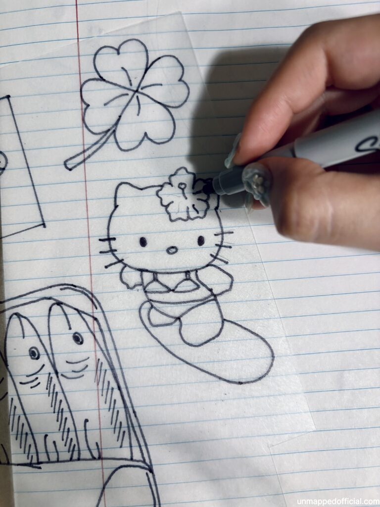 Tracing a shrinky dink shrink plastic with drawings over a paper sketch