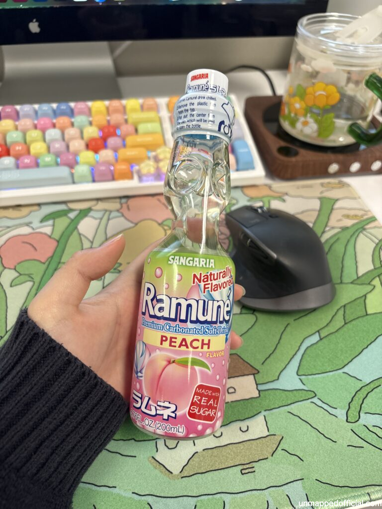 holding ramune bottle in front of work desk