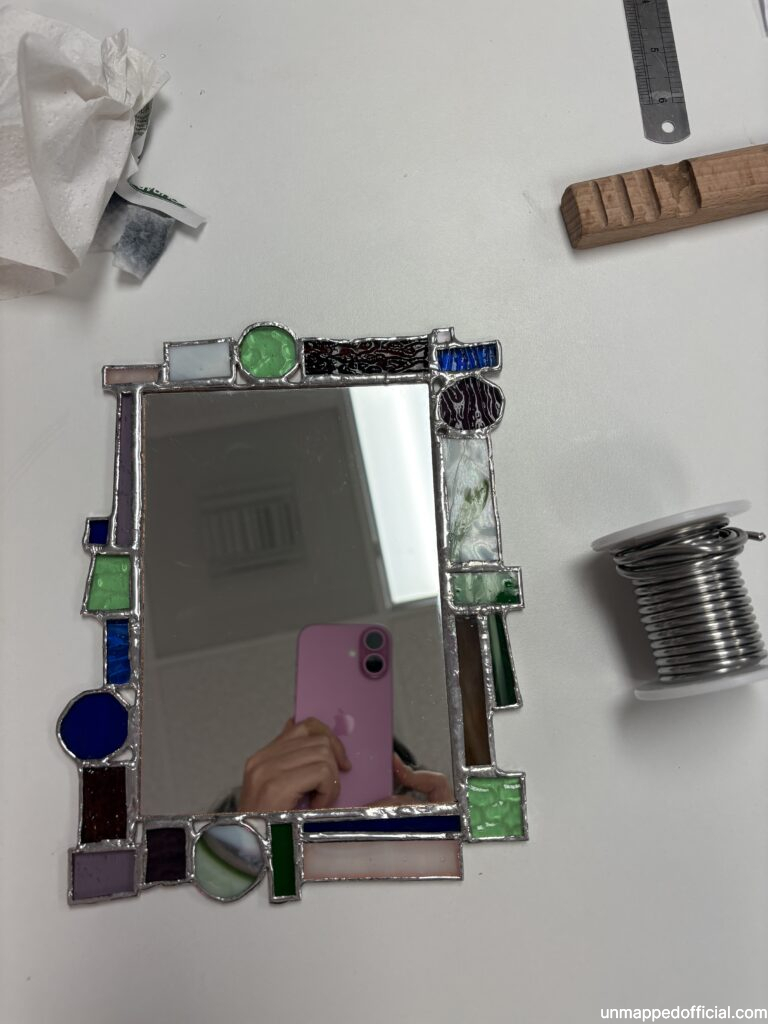 glass pieces soldered together onto a mirror